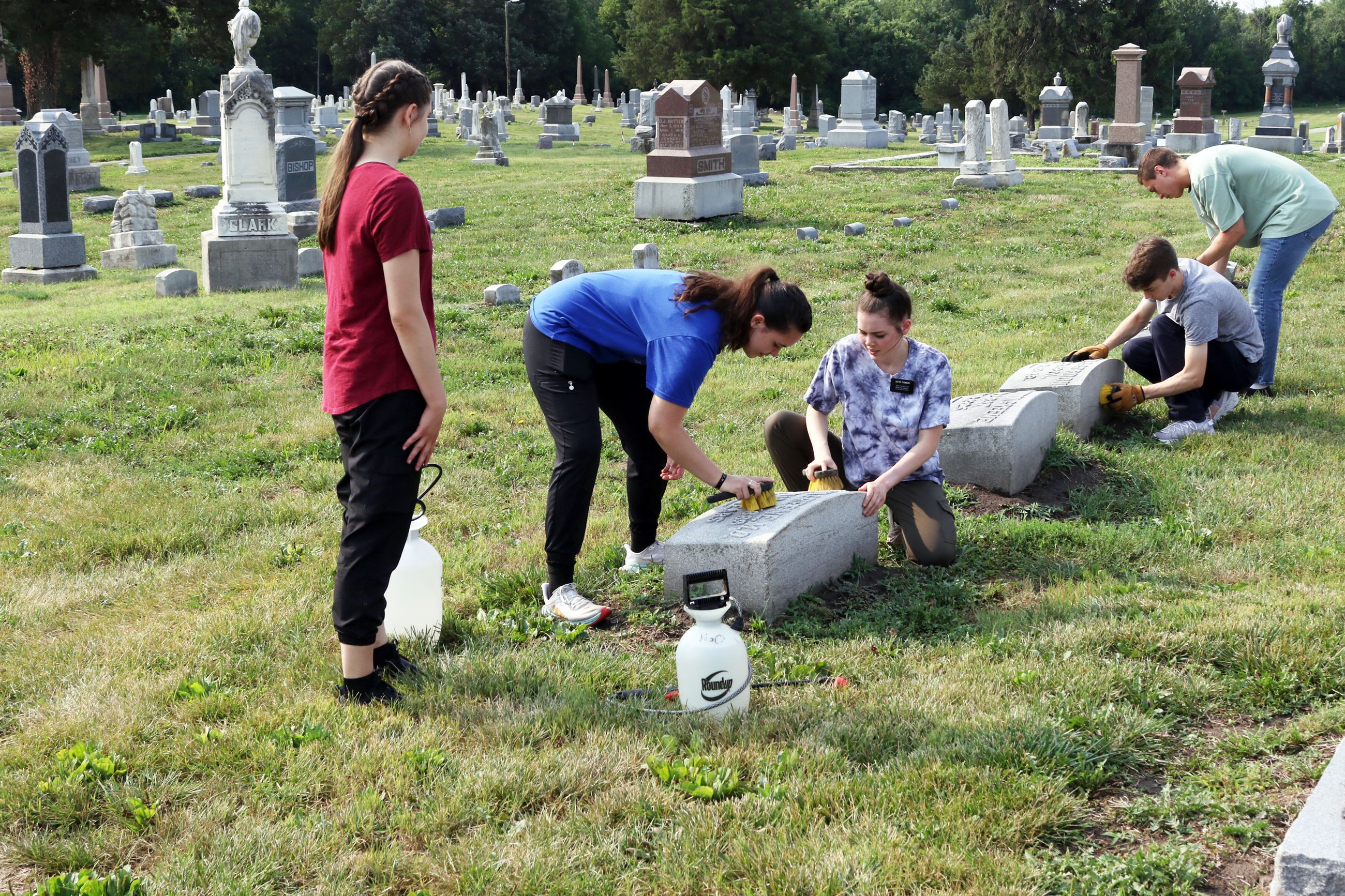 Volunteers Cleaning headstones at the Cemetery Work Day