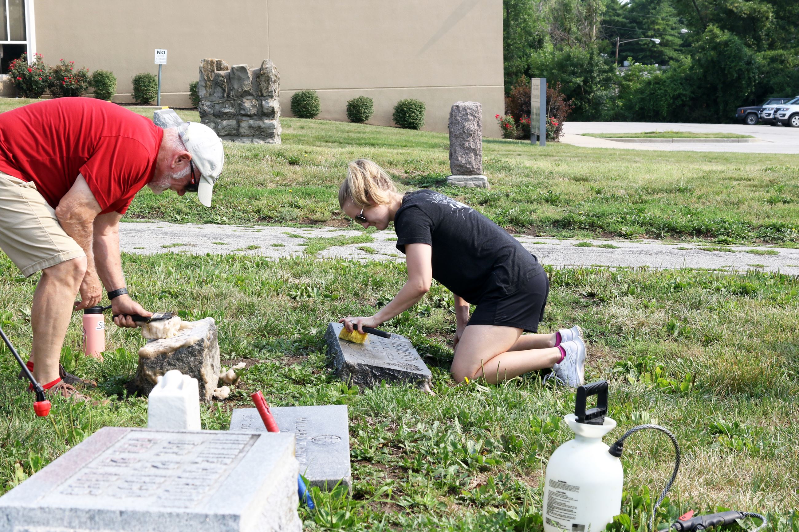 Volunteer Cleaning a headstone at the Cemetery Work Day