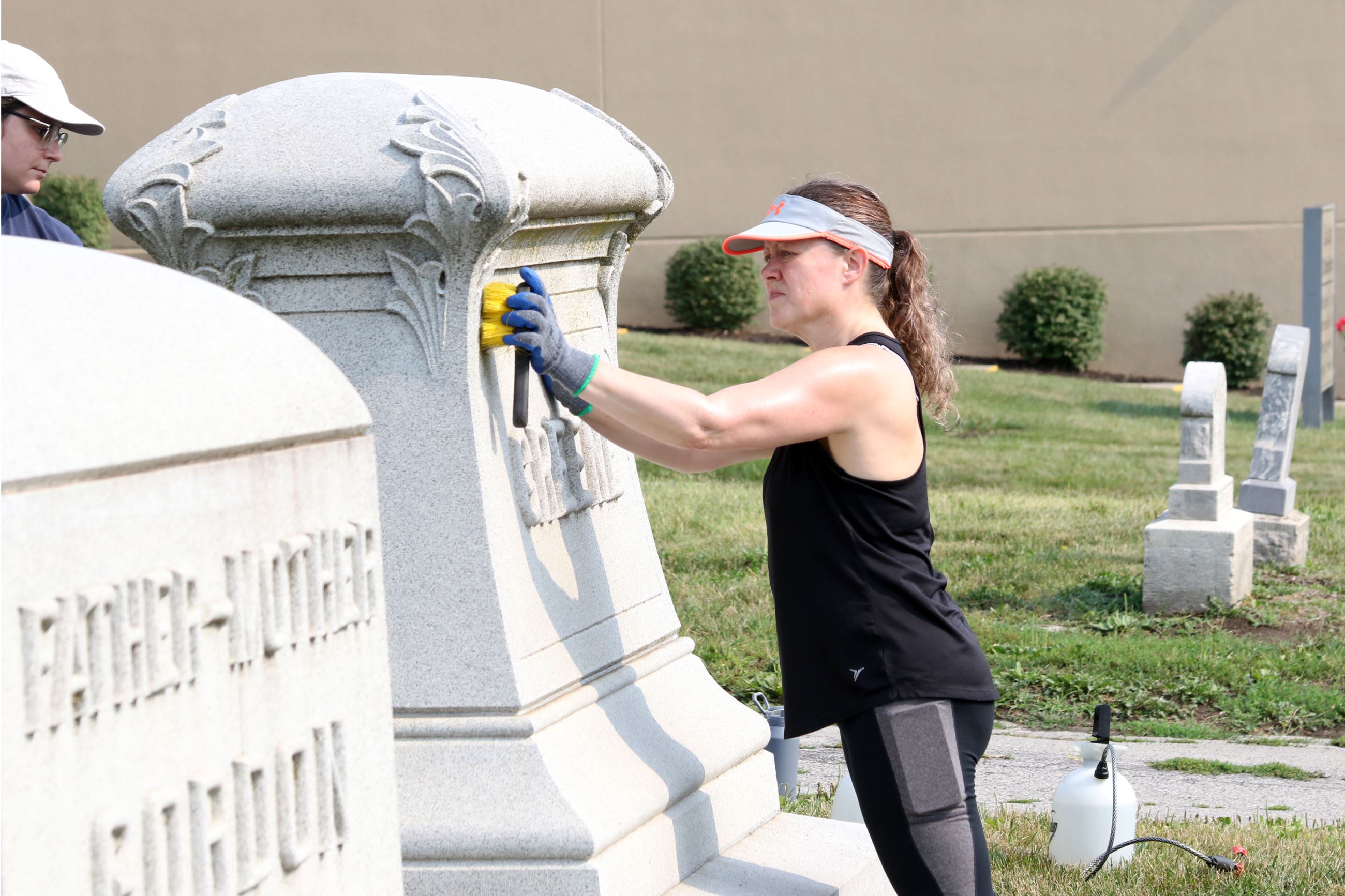 Volunteer Cleaning a headstone at the Cemetery Work Day
